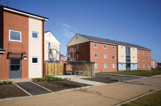 Path leading up to row of houses with mix finish of red brick and render, blue sky