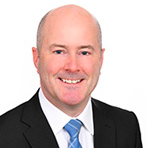 portrait photo of man with black suit jacket, white shirt and blue tie on white background