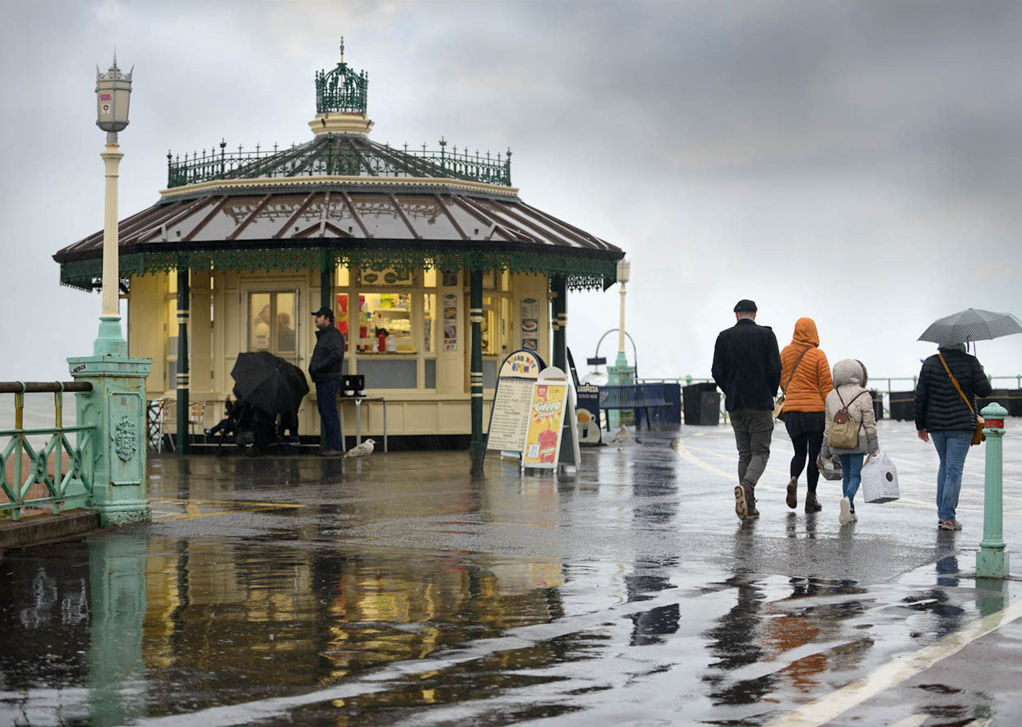 People walking along wet pathway, victorian kisok with PVCu render beading