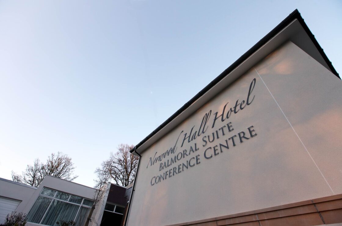 Side of building extension with signage on top of render finish with PVCu expansion joint, blue sky