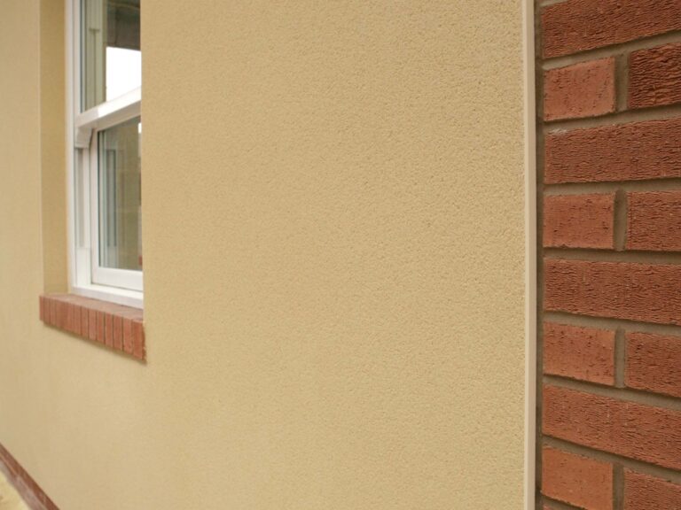 Red brick meets rendered wall with PVCu stop bead to separate materials, window along length of rendered wall