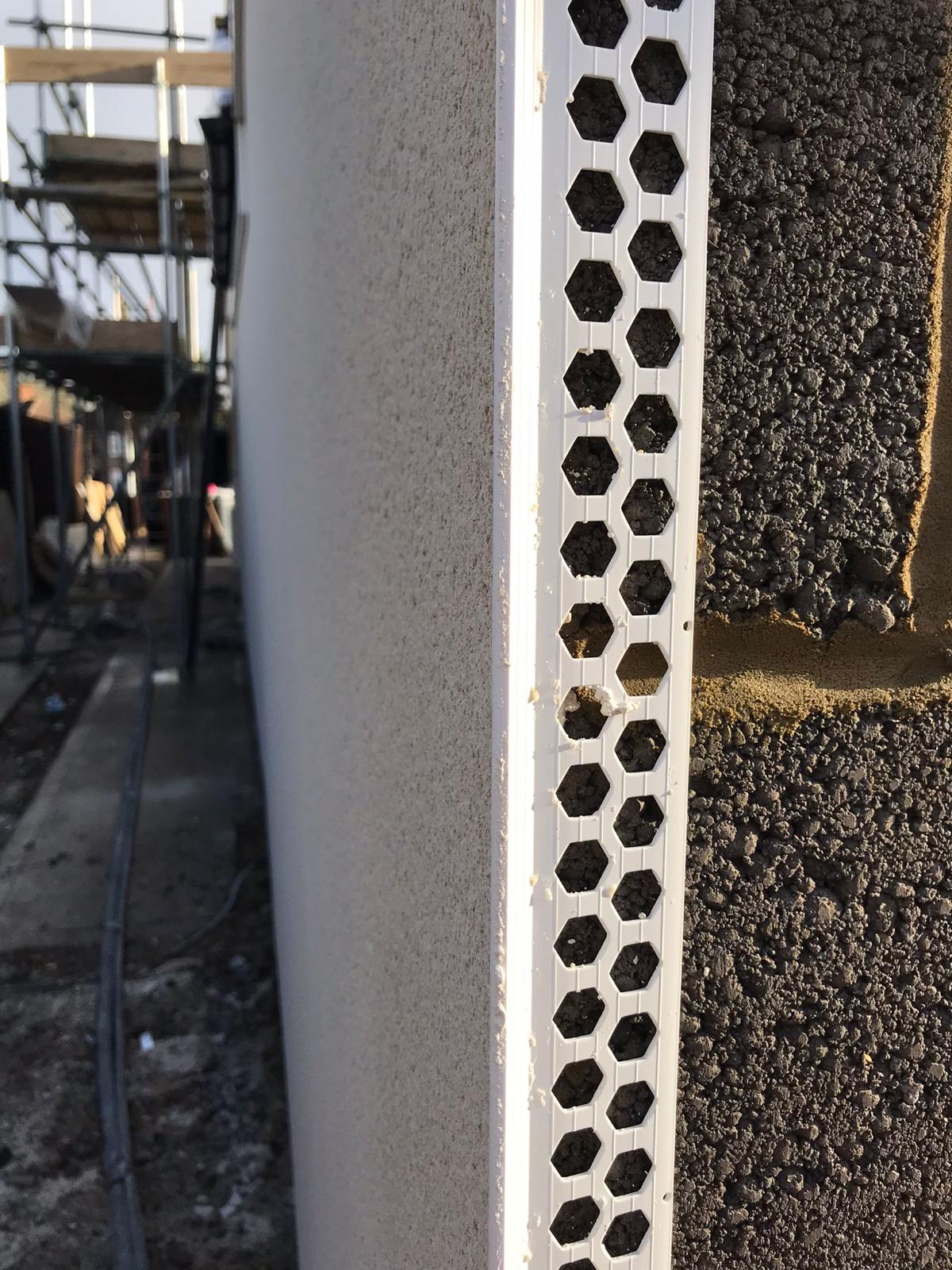 Close up image of white PVCu corner bead on breeze block with render applied to one side